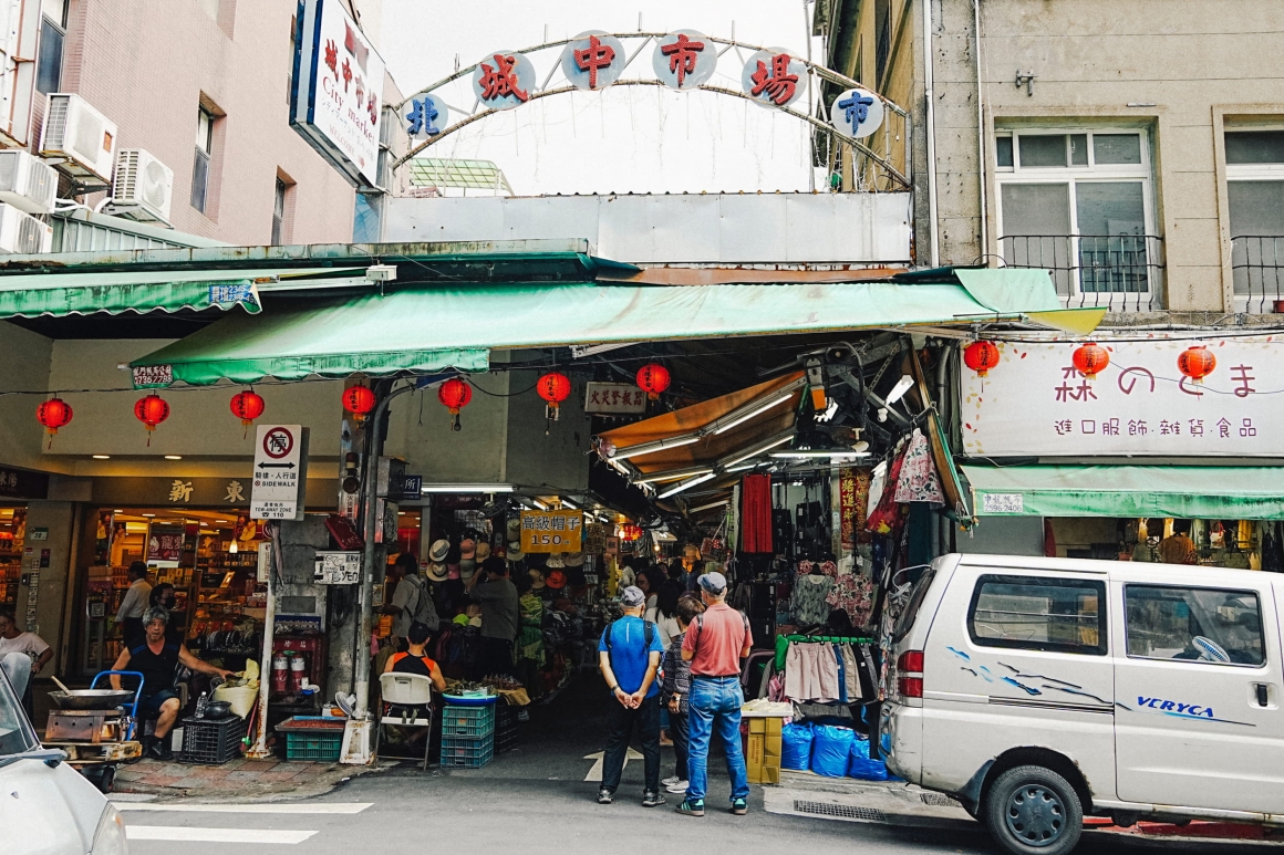 ภาพบริเวณทางเข้าตลาดเฉิงจง (Chengzhong Market) ที่ยังคงรักษาเสน่ห์ของตลาดดั้งเดิมไทเปเอาไว้ พร้อมบรรยากาศคึกคักของย่านการค้าที่มีชีวิตชีวา