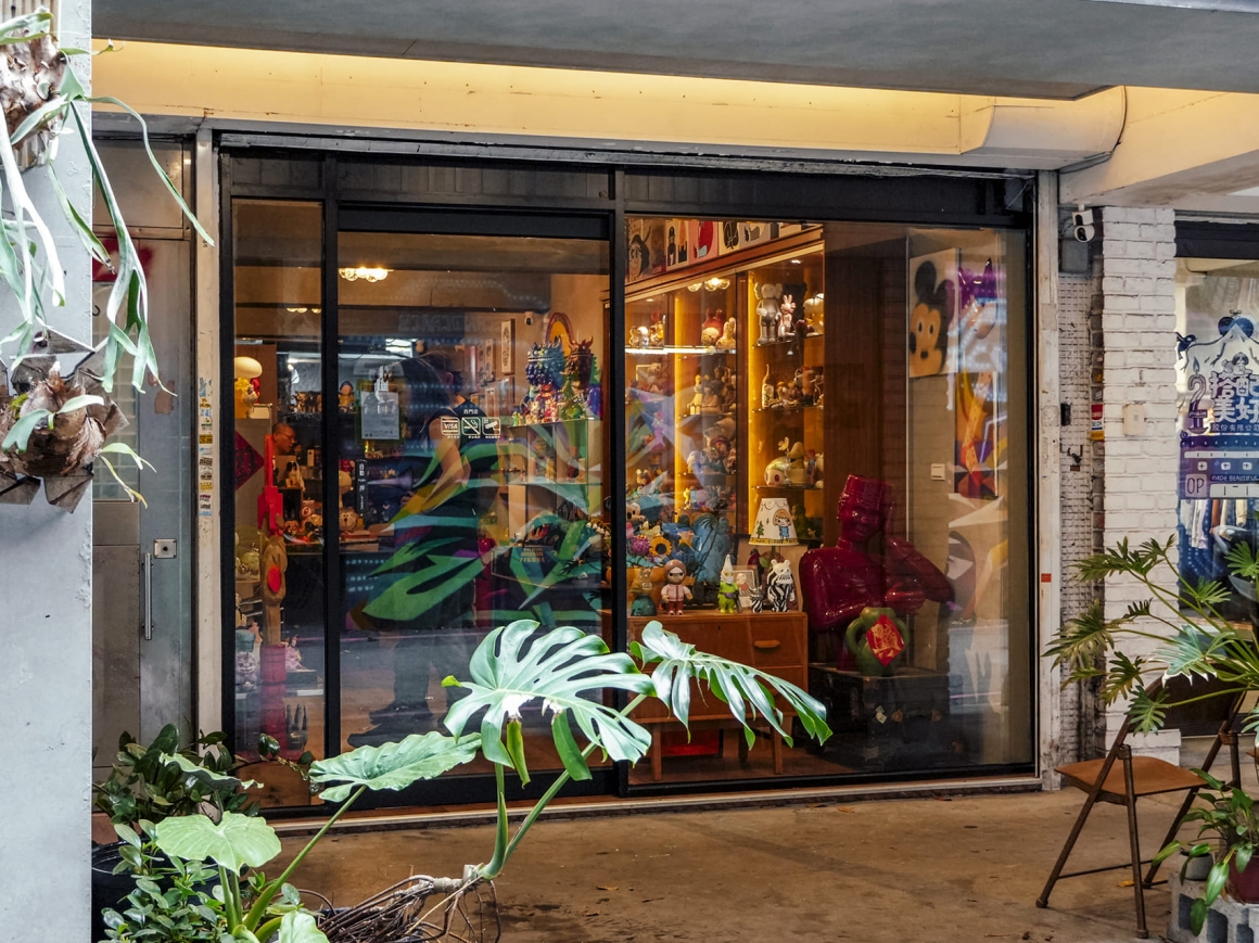 台北西門町美國街的復古公仔與玩具收藏店,玻璃櫥窗展示各式潮流玩具與特色收藏品,吸引喜愛復古文化與玩具收藏的遊客。